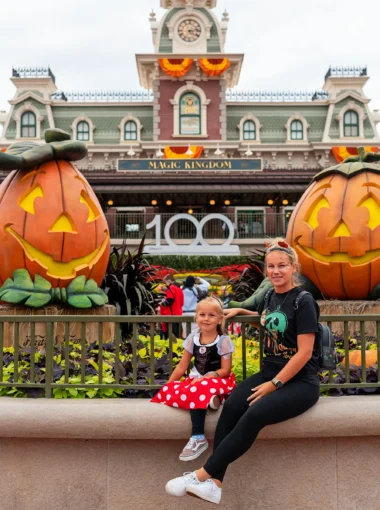 Marissa en Nina zitten voor de ingang van Magic Kingdom in Walt Disney World tijdens het Mickey's Not-So-Scary Halloween Party event.