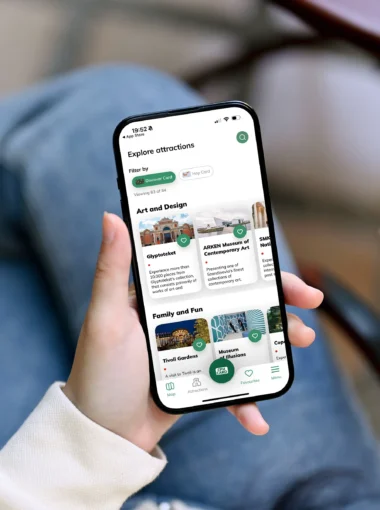 Een vrouw gebruikt de handige app van de Copenhagen Card op haar mobiele telefoon.